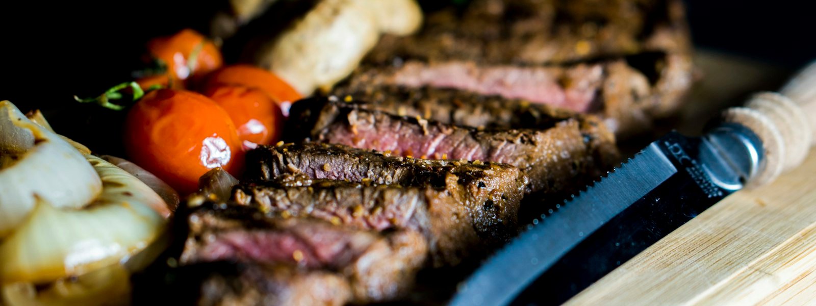 Sliced grilled steak with a steak knife