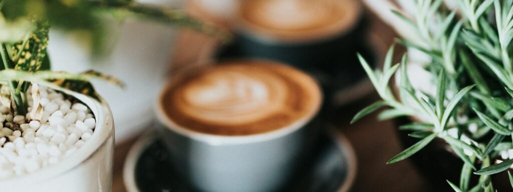 Latte with foam art in a white cup on a cafe table