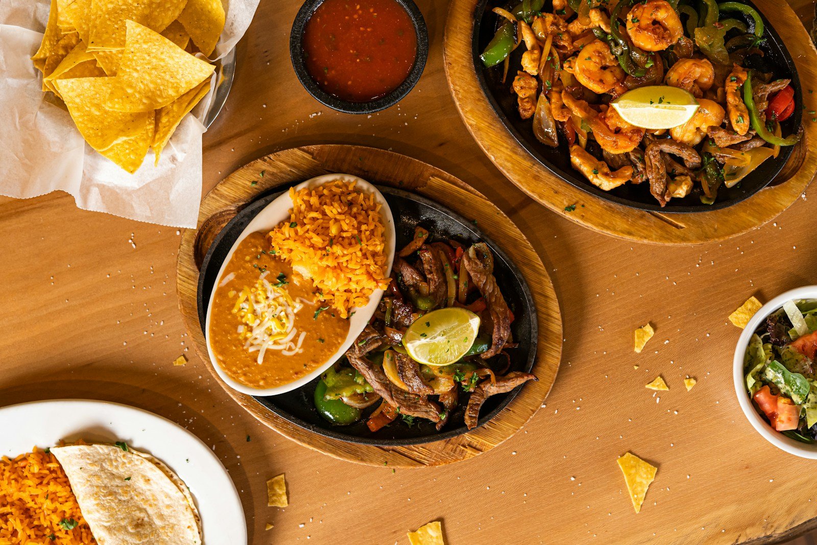Plates of tacos, fajitas and chips and salsa on a restaurant table